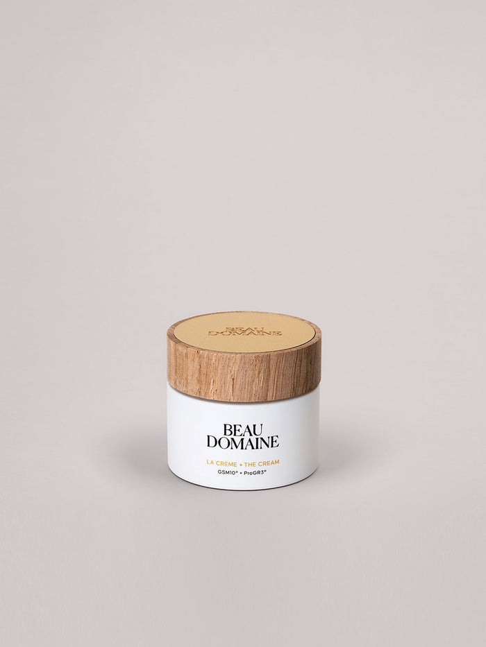 Pot blanc avec couvercle en bois portant la mention 'Beau Domaine' sur fond gris clair