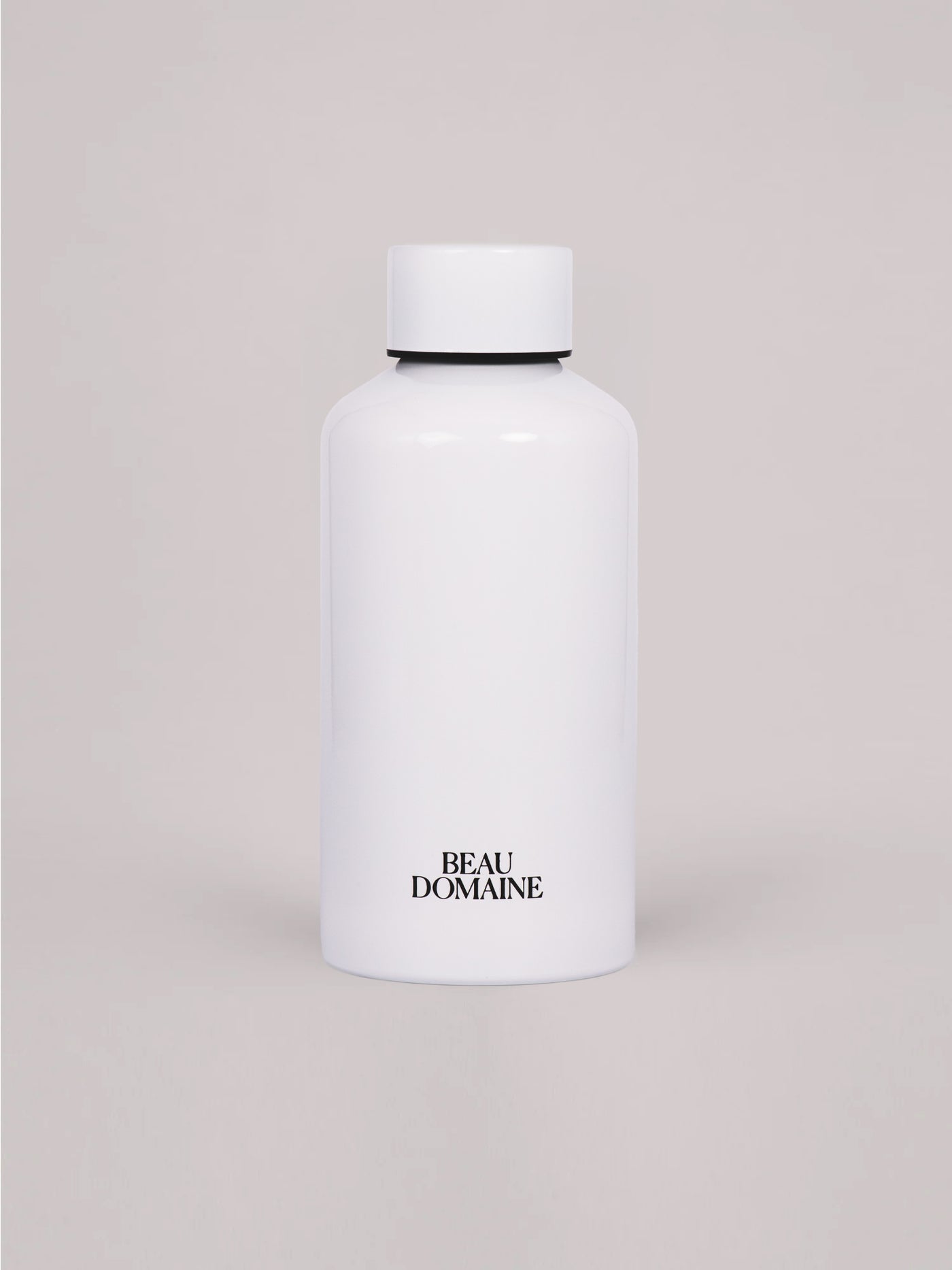 Weiße Flasche mit „Beau Domaine"-Branding auf beigem Hintergrund