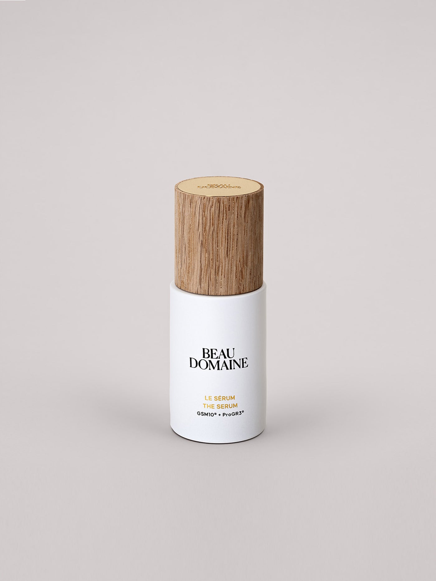 Flacon blanc avec bouchon en bois sur fond gris clair.